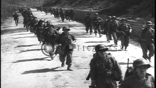 US Infantrymen advancing and a Mack truck towing a 155mm Long Tom across a bridge...HD Stock Footage