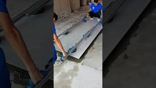 Two workers installing floor tiles