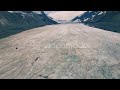 4k aerial drone shot of athabasca glacier over hikers nk9hx9b0