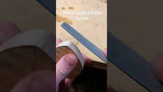 Hand filing high spots off wood.