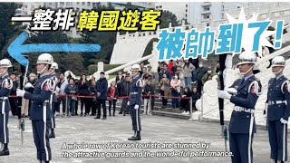 A whole row of Korean tourists are stunned by the attractive guards and the wonderful performance…