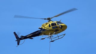 A Eurocopter AS350 Ecureuil helicopter helping out construction workers in Zug, Switzerland