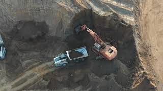 Hitachi EX1200-7 dumping dirt into dump truck