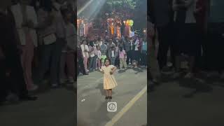 A little girl from Xinjiang dances on the street, displaying elegant movements with confidence