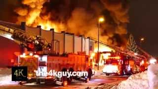 4K UHD - Two fire trucks battle an intense urban building fire.