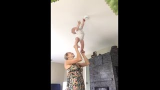 Little Baby Reach For The Ceiling While Practicing Acrobatics With His Mom