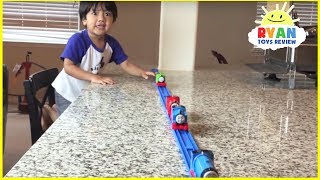Ryan plays with Thomas and Friends trains around the house