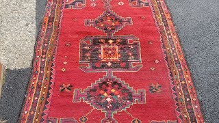 old hand knotted orental rug(Hamadan persian)gets dusted before cleaning