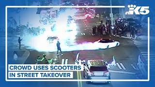 RAW: Crowd uses Lime scooters to block off intersection for street takeover