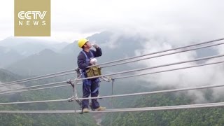 Men on wire: Power workers walk in the clouds to repair lines
