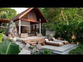 explore a modern tropical house with natural stones wooden logs and lush garden spaces