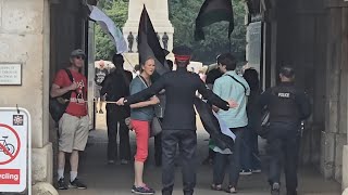 PALESTINE PROTESTERS RETURN BANGING DRUMS CORPORAL STOPS THEM ENETRING THE COURTYARD WITH FLAGS