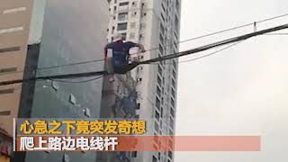 小伙等不及横穿马路  爬电线杆攀架空电线过大街