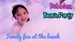 Family fun at the beach. Bubble beach party and blowing bubbles. Kids's birthday party ideas