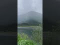 dark gray clouds low over the lake and green mountains in alaska nature lake clouds mountains