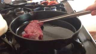 Cooking venison strip in a cast iron skillet