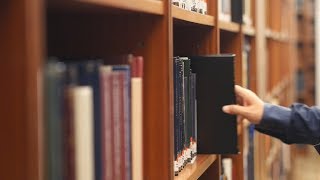 Man Picking Books in Library 01 / Free Stock Footage (4K)