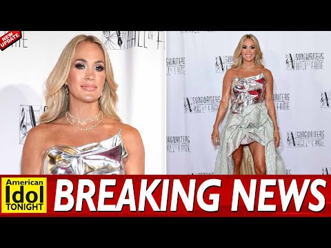 Carrie Underwood flashes her legs in glitzy high low gown with a silver chrome chest plate as she le
