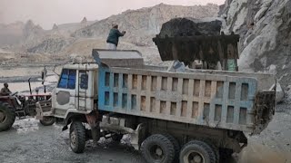 Heavy-duty Machinery at Heavy Work: Caterpillar 966D Loading Big Rocks into Big Dump Trucks