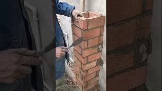 Skilled bricklayer making brick chimney