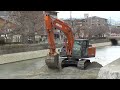 japanese hydraulic excavators dig up river sediment.