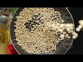 slow motion raw peeled cedar nuts being poured on the black frying pan