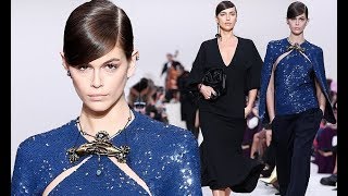 Kaia Gerber sparkles in a sequinned caped top as she joins a chic Irina Shayk to light up the runway