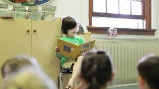 7 year old reading a story to preschool
