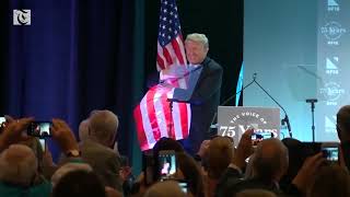 Trump embraces flag, literally