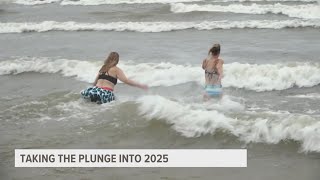 Group takes New Year's Day cold plunge dip into Lake Michigan