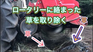 トラクターのロータリーに絡まった草を取り除く