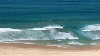 Surfers using rip current to paddle out easily