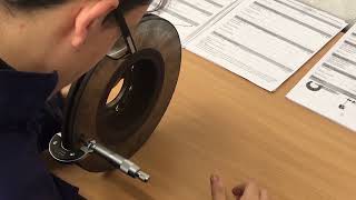Measuring Brake disc runout in the workshop using a micrometer.
