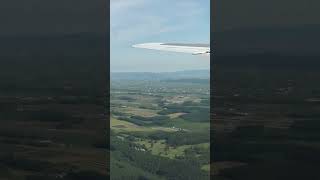 夏の北海道 旭川空港上空から遠くにビルが林立する旭川市街が見えるAIRDO-B767機内窓からの景色