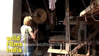 Tourist takes photograph of workers at coir factory in Kerala