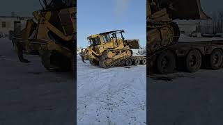 Unloading a cat off the back of a lowboy