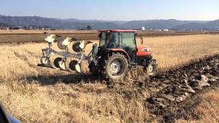 Kubota KL550 ploughing a rice field in Japan. Japán traktor váltva forgató ekével dolgozik.