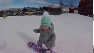 Une petite fille de 1 an fait du snowboard