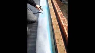 Spray adhesive on parapet wall with RubberBond EPDM roofing