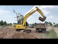 komatsu pc200 8m0 is excavating soil called gravel to stock.