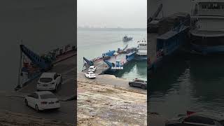 Truck drivers are queuing up at the riverside to board the ferry to cross the river. There are t