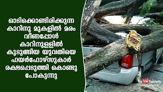 മരം വീണപ്പോൾ കാറിനുള്ളിൽ കുടുങ്ങിയ യുവതിയെ ഫയർഫോഴ്സുകാർ രക്ഷപ്പെടുത്തി കൊണ്ടു പോകുന്നു