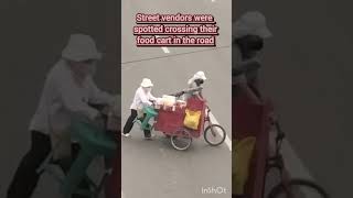 Street vendors were spotted dangerously crossing their makeshift food cart in the road