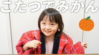 半纏を着てこたつでみかんを食べる3歳娘