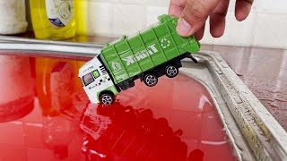 Various diecast cars moving and falling into the red water