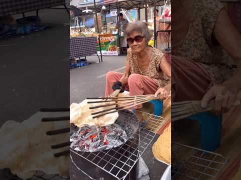 Abuela trabajadora vendiendo galletas saladas grandes: comida callejera tailandesa