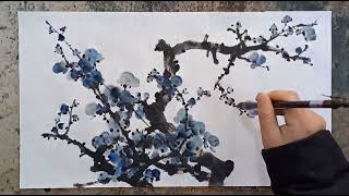 Artist painting Plum blossom with a traditional Chinese brush