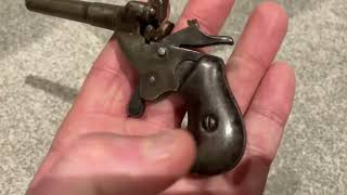 FIRING AN ANTIQUE MINIATURE POSTMAN POCKET PISTOL.