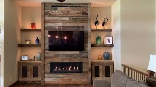 Custom barnwood fireplace with built-in barnwood cabinets and floating shelves