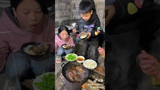 A family sits in a small kitchen and enjoys a simple but delicious meal. This kind of rural life